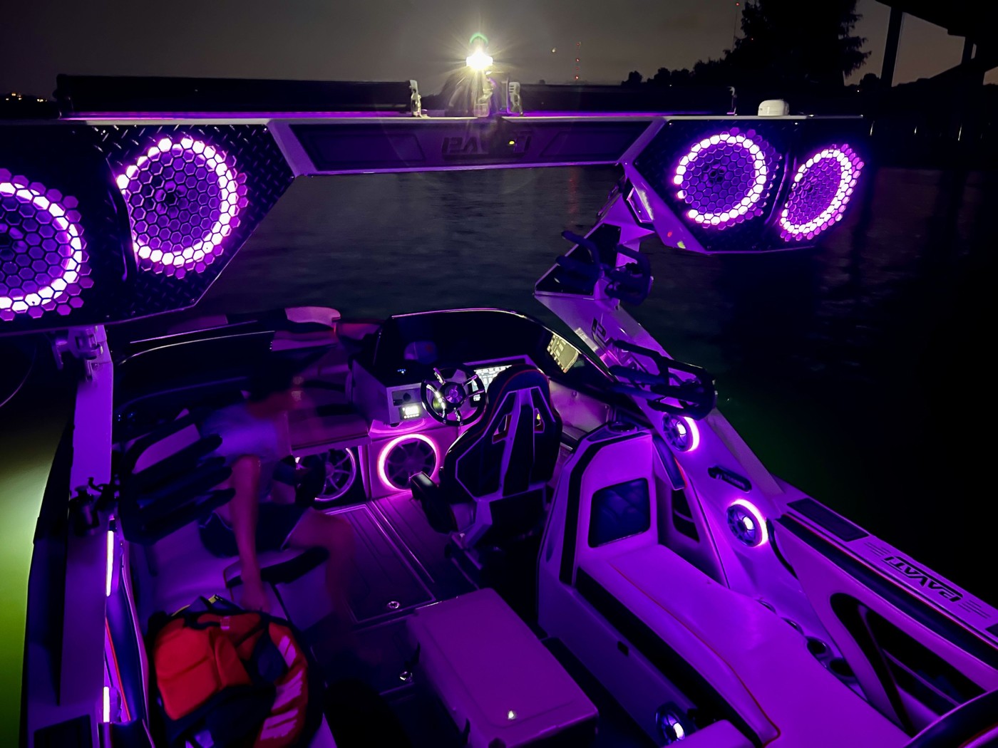 Surf boat with illuminated tower speakers and purple LED interior lighting